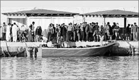  ??  ?? Migrants stand on a dock as they disembark a boat on the Sicilian Island of Lampedusa, Italy July 24, 2020. ( Photo : Reuters )