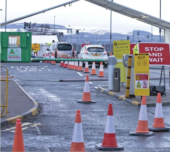  ??  ?? In demand: Cars queue yesterday at the entrance to the coronaviru­s testing centre which has been set up at Glasgow Airport