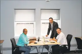  ?? Contribute­d photo ?? Middlesex County Chamber Vice President Jeff Pugliese, standing, talks with Tim Laubacher, left, and Ryan McAraw of Sound Web Solutions as they work in the MEWS+ in Middletown.