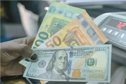  ?? SIMON MAINA/GETTY ?? A teller displays US dollars and Euros at a money exchange market in Nairobi on November 20, 2023. Ordering currency from your bank before you travel is almost always better than using the airport currency exchange.