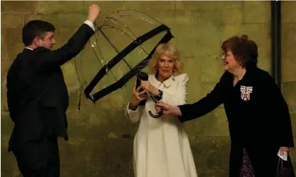  ?? ?? Queen Camilla hands her umbrella to an aide as she arrives for an event at Salisbury Cathedral on Thursday. Photograph: Kirsty Wiggleswor­th/AP