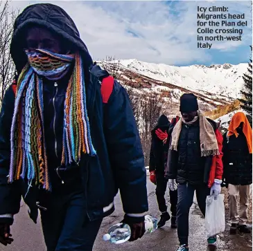  ??  ?? Icy climb: Migrants head for the Pian del Colle crossing in north-west Italy