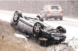  ?? Scott Mason / Winchester Star via Associated Press ?? There were no injuries when this vehicle overturned Friday on a snow-covered U.S. 522 near Gainesboro, Va., but at least nine people died in other storm-related crashes as the icy conditions quickly became treacherou­s.