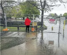  ?? BOB TYMCZYSZYN/STANDARD STAFF ?? Water levels keep rising on Lake Ontario causing major problems in Port Dalhousie. A woman looks out over the flooded areas of Lakeside Park.