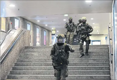  ??  ?? ARMED POLICE: Officers walk through the undergroun­d station Karlsplatz (Stachus) after the shooting. Picture: Andreas Gebert