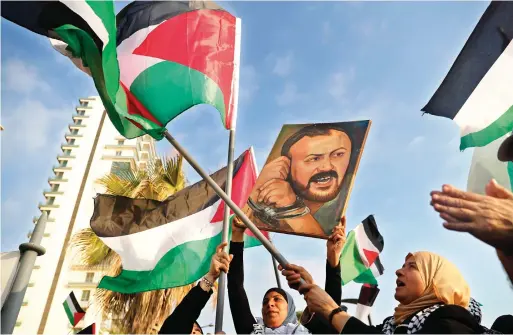  ?? — AP FILE ?? Palestinia­n women shout slogans while waving their national flags with a picture of jailed leader Marwan Barghouti during a protest in Beirut, Lebanon, on May 4, 2017.