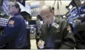  ?? RICHARD DREW — THE ASSOCIATED PRESS ?? Trader Andrew Silverman, right, works on the floor of the New York Stock Exchange, Wednesday. After a shaky start, U.S. stocks finished mostly higher Wednesday as technology and industrial companies rose.