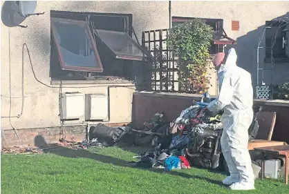  ??  ?? Forensics officers examine the scene of the blaze at the flat in River Street, Brechin.