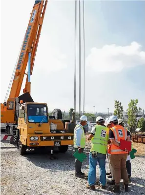  ??  ?? Moving up: Trainees learning how to properly conduct a lifting operation using a mobile crane at the centre.