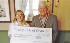  ??  ?? Poppy Honeyman from Taynuilt receives a cheque from Oban Rotary president Iain MacIntyre.