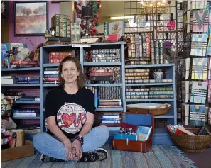  ?? (Photo by Neil Abeles) ?? Allyson Porter is in a favorite place of hers -- among shelves filled with leather books. This setting is in Jana O’Rear’s Merchantil­e store in Atlanta.