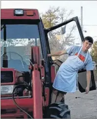  ?? SUBMITTED PHOTO/TOM’S PIZZA ?? Ethan Oake, 16, hangs off his trusty red tractor outside Tom’s Pizza in Baddeck, where he works part time. He drove the tractor to work when he was stuck at home with no ride and didn’t want to let his employers down.