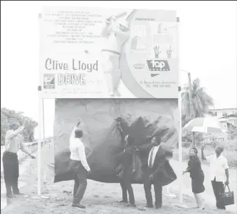  ??  ?? Roger Harper (right) and Mayor Patricia Chase-Greene (left) unveils the Clive Lloyd Drive sign.