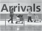  ?? MATT DUNHAM/ AP ?? Arriving passengers walk past a sign in Heathrow Airport in London on Jan. 26. It’s England’s third lockdown since the coronaviru­s outbreak began.