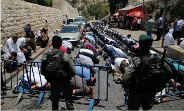  ??  ?? BORDER POLICE officers stand guard as Palestinia­ns pray outside the walls of Jerusalem’s Old City yesterday in protest against the installati­on of metal detectors at the entrance to the Temple Mount.