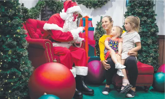  ?? ?? Stephanie Mcnulty and kids, Ava, 4, and Claudia, 2, meet Santa at Melbourne’s Myer Santa wonderland. Picture: NCA Newswire/sarah Matray