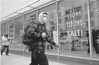  ?? [STEVEN SENNE/ THE ASSOCIATED PRESS] ?? A man walks past a store closing sign in the window of a department store on Tuesday in Boston. Americans may feel whiplashed by a report issued Thursday on the economy's growth this summer, when an explosive rebound followed an epic collapse. The government will likely estimate that the economy grew faster on an annualized basis last quarter than in any such period since record-keeping began in 1947.