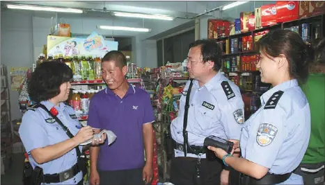  ??  ?? Local police talk to a shopkeeper about an issue. Recently launched nighttime police patrols help locals feel more secure.