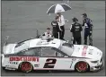  ?? PHELAN M. EBENHACK — THE ASSOCIATED PRESS ?? Brad Keselowski stands under an umbrella on pit road as rain forces a red flag during the NASCAR Daytona 500auto race at Daytona Internatio­nal Speedway, Sunday, in Daytona Beach, Fla. The race did not complete by this edition’s deadline. See coverage on Tuesday’s Mercury.