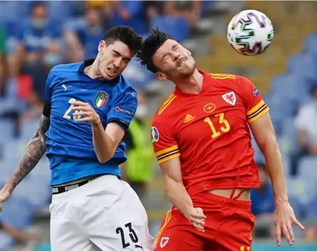  ?? AFP ?? El defensor italiano Alessandro Bastoni (izq.) y el galés Kieffer Moore disputan el balón durante el partido de este domingo en Roma.