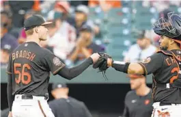  ?? JULIO CORTEZ/AP ?? Orioles pitcher Kyle Bradish, left, fist-bumping catcher Robinson Chirinos, says the pitch clock didn’t seem to affect him much in Triple-A. Others have had more mixed reactions to it.