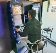  ??  ?? Al bar Un giocatore alla slot machine (archivio)