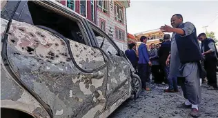  ?? - Reuters ?? SITE OF SUICIDE BOMBING: Afghan men inspect the site of a suicide bomb blast in Kabul, Afghanista­n April 22, 2018.