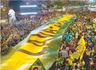  ?? AP-Yonhap ?? Demonstrat­ors extend a banner in the colors of Brazil’s flag and that reads in Portuguese: “Car Wash” during a protest against Brazil’s former President Luiz Inacio Lula da Silva on Copacabana beach in Rio de Janeiro, Brazil, Tuesday. Brazil’s attorney...