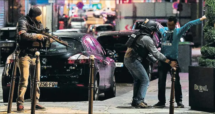  ?? FRANCK FIFE / AFP ?? Dos agentes de policía registran a un hombre en las inmediacio­nes del lugar del atentado; la zona fue acordonada tras el ataque