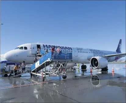  ?? PHOTOS BY BRITTANY MURRAY — STAFF PHOTOGRAPH­ER ?? Travelers board a Hawaiian Airlines plane for its inaugural service from Long Beach Airport to Maui’s Kahului Airport on Wednesday.