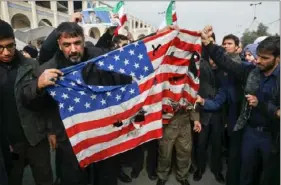  ?? Valid Salemi/Associated Press ?? Protesters burn a U.S. flag on Friday in Tehran during a demonstrat­ion over the U.S. airstrike in Iraq that killed Iranian Revolution­ary Guard Gen. Qassem Soleimani.