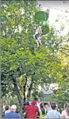  ??  ?? SCARY: A 14-year-old dangles 25 feet above the ground from a ride at Six Flags near Albany before landing in the arms of onlookers.