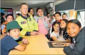  ?? PHOTO / TANIA WHYTE ?? Raurimu Ave School students with firefighte­r Justin Rankin after being evacuated to the Onerahi Fire Station.