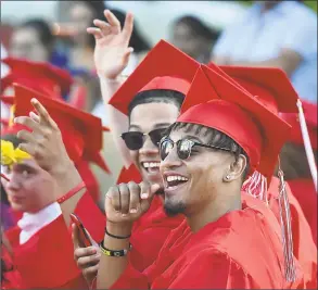  ?? Catherine Avalone / Hearst Connecticu­t Media ?? Eli Alexander, right, and Jaden Atkinson Whittingha­m wave to a friend at graduation exercises Tuesday.