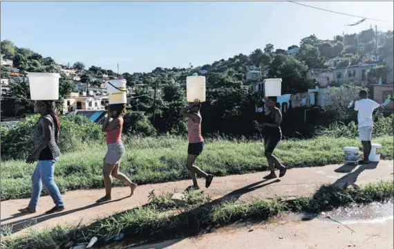  ?? Photos: Rajesh Jantilal/getty Images & Michele Spatari/getty Images ?? Life lines: People carry buckets with water (above) from a municipal water tanker near Durban, after floods in the region in 2022. An City of Tshwane employee collects a sample of water from a municipal tank truck in Hammanskra­al, where a cholera outbreak killed 15 people earlier this year.