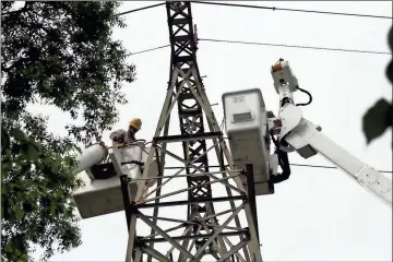  ??  ?? ABOVE: Rick Gilmer (left) works to disconnect a power transmissi­on line on a tower at the edge of Heritage Park. The entire line is being taken down.LEFT: Utilicon electrical contractor­s work to remove a transmissi­on line from a large tower in Heritage Park. Ray Thompson, an independen­t contractor for Georgia Power, said that if all goes well crews will be out of the park by the end of June.BELOW: Ab Eakes (left) and Jared Carswell remove supports from a power pole that was taken down in Riverview Park. Photos by Doug Walker