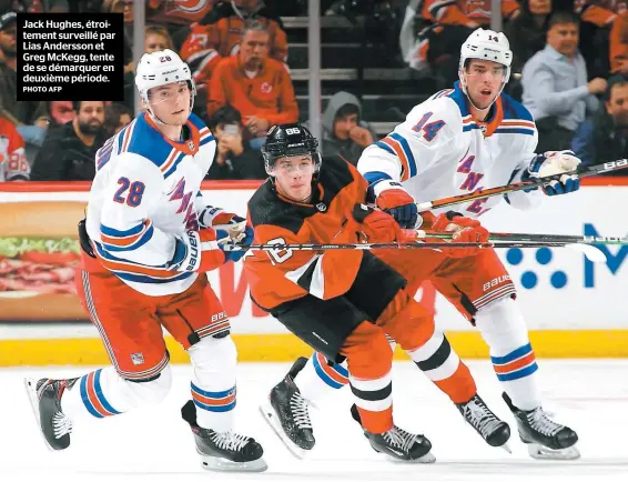  ?? PHOTO AFP ?? Jack Hughes, étroitemen­t surveillé par Lias Andersson et Greg Mckegg, tente de se démarquer en deuxième période.