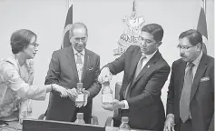  ??  ?? Natural Resources and Environmen­t Minister Datuk Seri Dr Wan Junaidi Tuanku Jaafar (second left) showing a sample of contaminat­ed water in Selangor to Azmin (second right) during their meeting at the Menteri Besar’s office. — Bernama photo