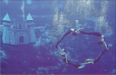  ?? [CHRIS O’MEARA/ THE ASSOCIATED PRESS] ?? Live “mermaids” of Weeki Wachee Springs perform in September 2003. The mermaids are able to remain underwater for 30 minutes at a time with the assistance of a tube they can use to take in air during the dances.