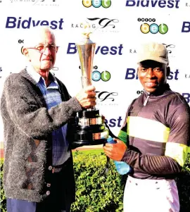  ?? Picture: JC Photograph­ics ?? WE REMEMBER. Jockey S’manga Khumalo, who rode Matador Man to victory in the 30 Year Anniversar­y Hennenman Memorial Progress Plate at Turffontei­n on Saturday, receives his trophy from Dries Botha, a relative of Bennie de Wet, one of the 13 jockeys who...