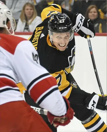  ?? Peter Diana/Post-Gazette ?? Nick Bjugstad battles Carolina center Greg McKegg for possession in the Penguins’ 4-0 loss to the Hurricanes Tuesday night at PPG Paints Arena.