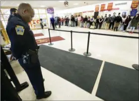  ?? BUTCH COMEGYS — THE TIMES-TRIBUNE VIA AP ?? Patrolman John Burgette, 53, a school resource officer for 18 years, bows his head as Scranton High School students stand in silence to protest gun violence for 17 minutes at the high school in Scranton, Pa.