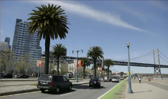  ?? Eric Risberg/Associated Press ?? Cars make their way along the Embarcader­o, with the San Francisco-Oakland Bay Bridge in the background.