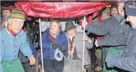  ?? FOTO: ANTHIA SCHMITT ?? Die Stegstreck­er bringen das „Kaiser“-Paar Sonja und Paul Woerz mit einer Sänfte zum Marktplatz, wo sie sich stilvoll von den langjährig­en Wirtsleute­n verabschie­den.