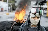  ?? MIGUEL GUTIERREZ/EPA ?? Anti-government protesters block a street Wednesday in Caracas, Venezuela. At least 75 people have died in clashes.