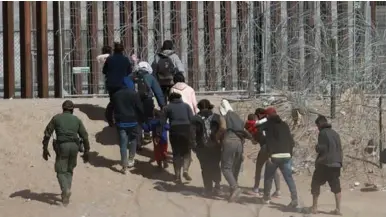  ?? ?? CRUCE. Un grupo de migrantes llega a la frontera que divide México y EE UU en Ciudad Juárez.