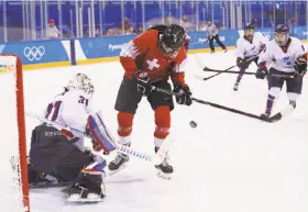 ?? Ronald Martinez / Getty Images ?? Switzerlan­d’s Evelina Raselli tries to score on Korea goalie Shin So Jung on the first day of the Olympic hockey tournament. The home team was outshot 52-8 on the ice, but off the ice the effort was seen as more successful.