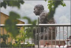  ?? (File Photo/AP/Keith Srakocic) ?? The statue of Public Broadcasti­ng Service’s Fred Rogers, the host of children’s program Mister Rogers’ Neighborho­od, is visible May 22 behind the fencing in the closed-off park area where the statue is located, during this year’s “1-4-3 Day” in Pittsburgh.