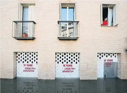  ?? ALAERT GEA / REUTERS ?? Un home parla amb el personal de rescat que patrulla una zona inundada a Tudela