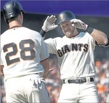  ?? KARL MONDON — STAFF PHOTOGRAPH­ER ?? Evan Longoria, right, celebrates his first hit as a Giant — a two-run homer in the seventh inning during Tuesday’s home opener against the Seattle Mariners — with teammate Buster Posey. The Giants fell to the Seattle Mariners 6-4.